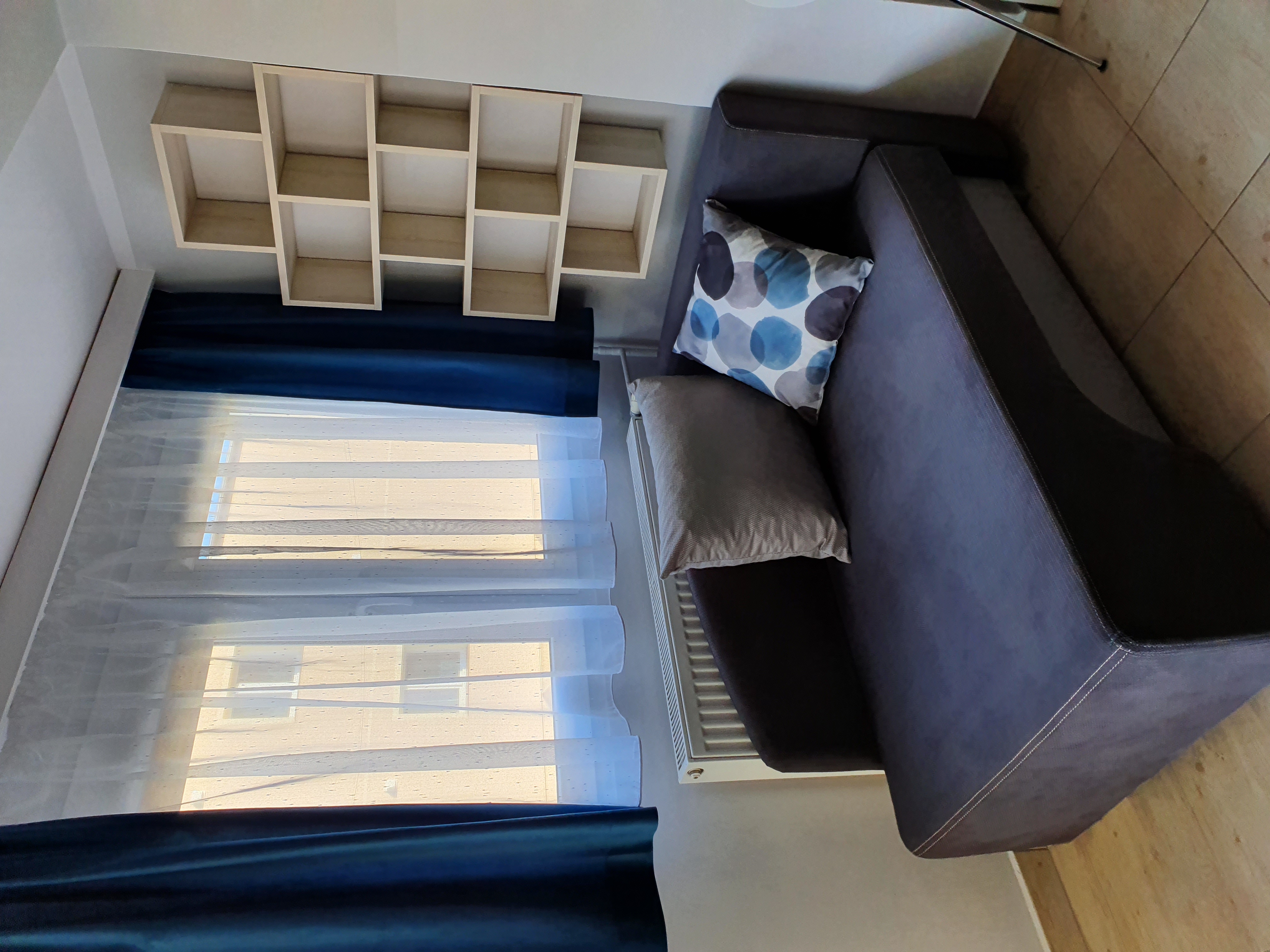 Galeria: Pokój z jednoosobową sofą i regałem