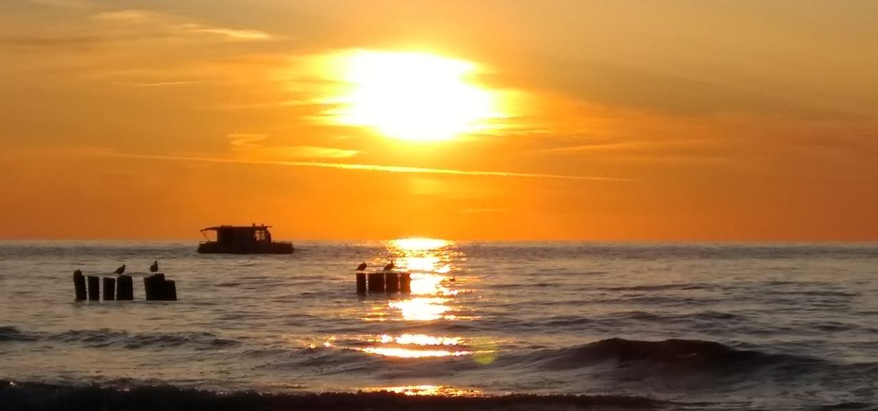 Galeria: Zachód słońca nad morzem z łódką